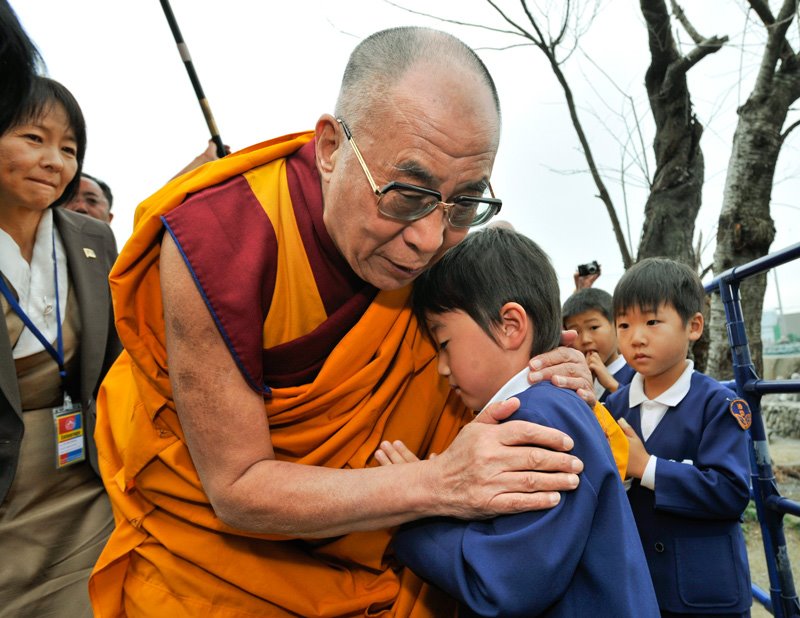 HHDL comforts a young boy who lost his parents to the tsunami